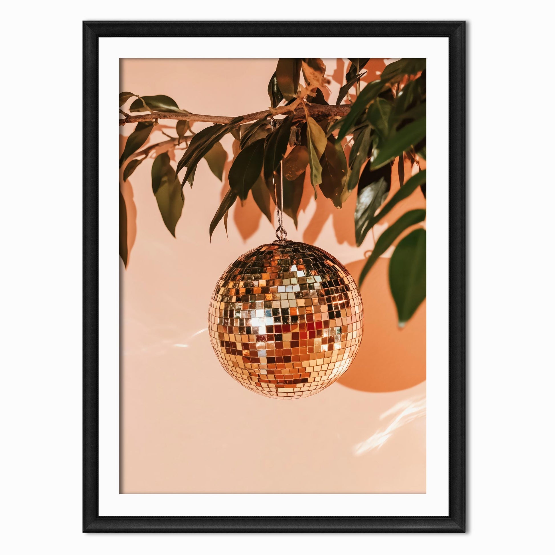 photography art print of a disco ball made to look like an orange hanging from a tree branch with leaves on it shown in a black frame