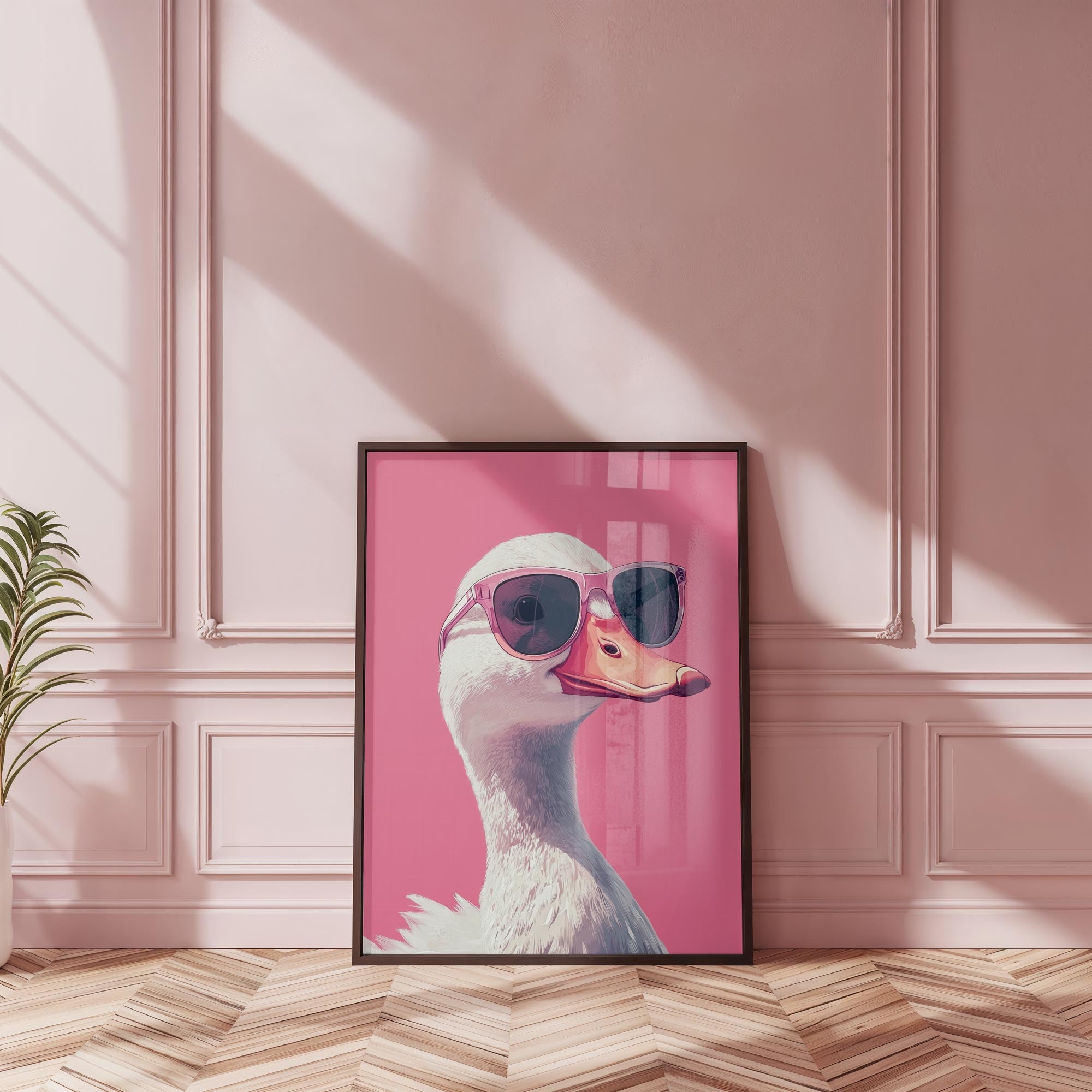 painting of a white duck in sunglasses on a pink background in a black frame leant against a pink wall